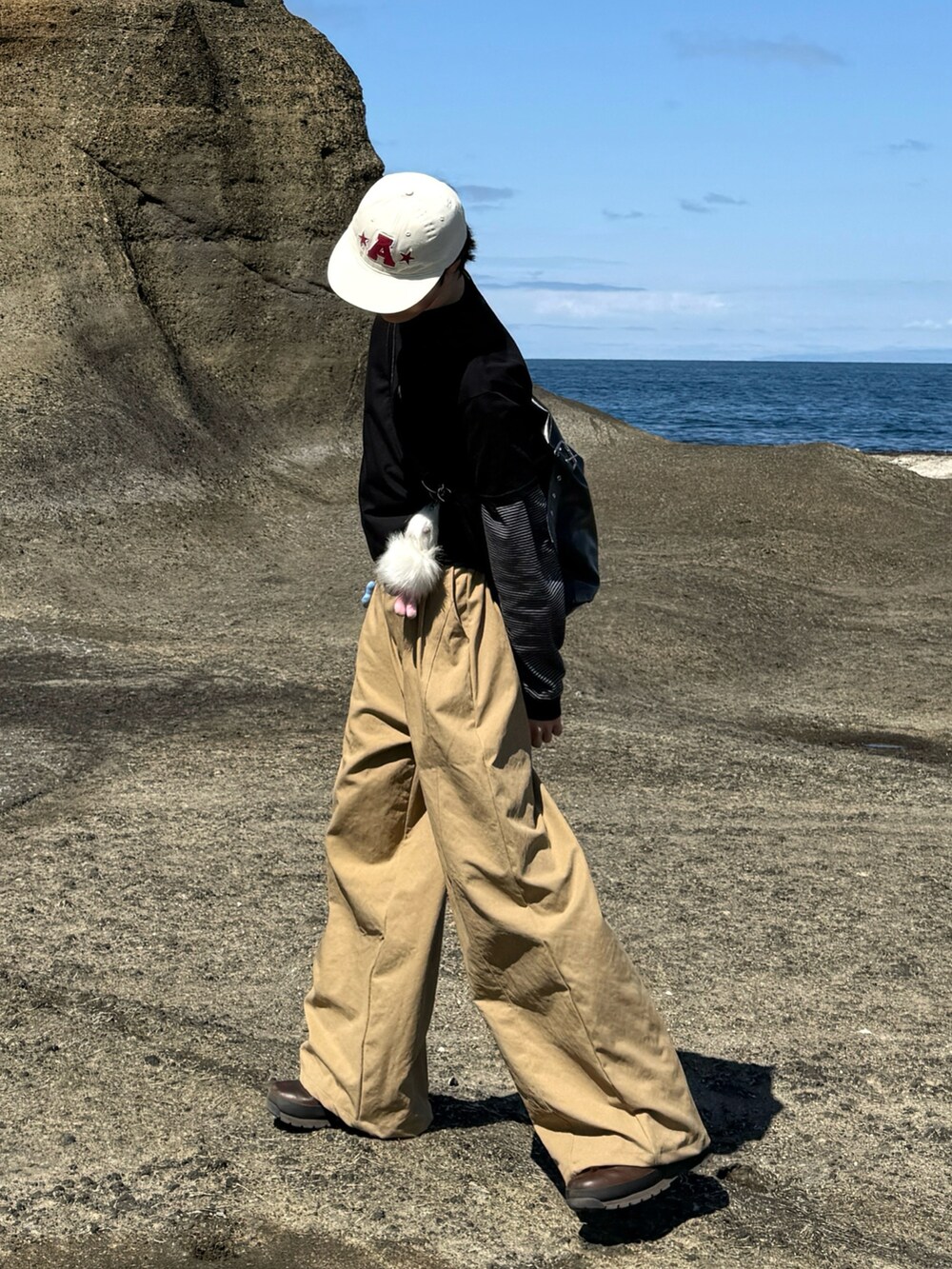ブラック系のTシャツ/カットソー、ブラック系のTシャツ/カットソー、ベージュ系のチノパンツを着用したメンズの春コーディネートの2枚目の写真