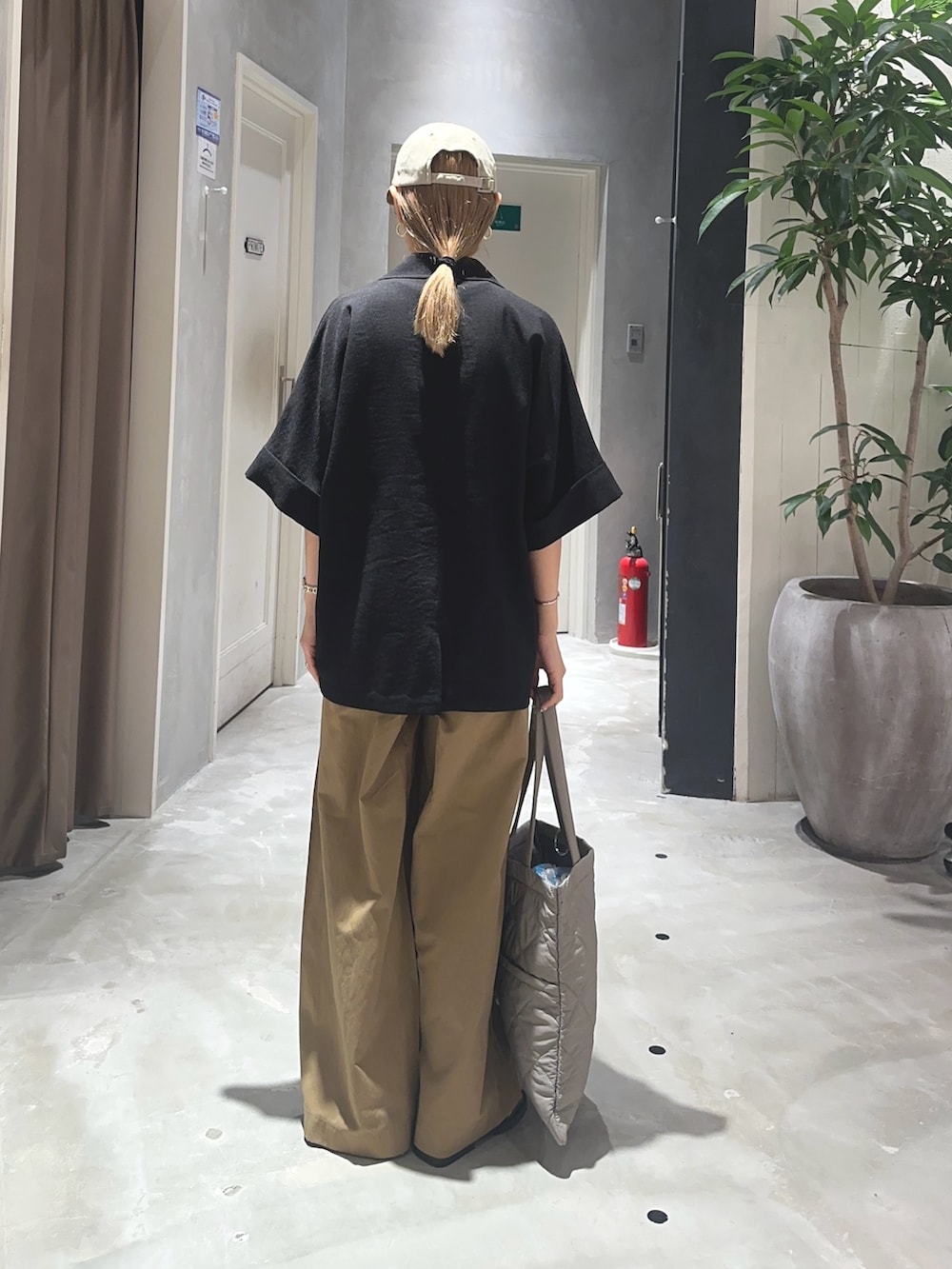 ベージュ系のデニムパンツ、ブラック系のテーラードジャケット、グレー系のトートバッグを着用したレディースの夏コーディネートの2枚目の写真