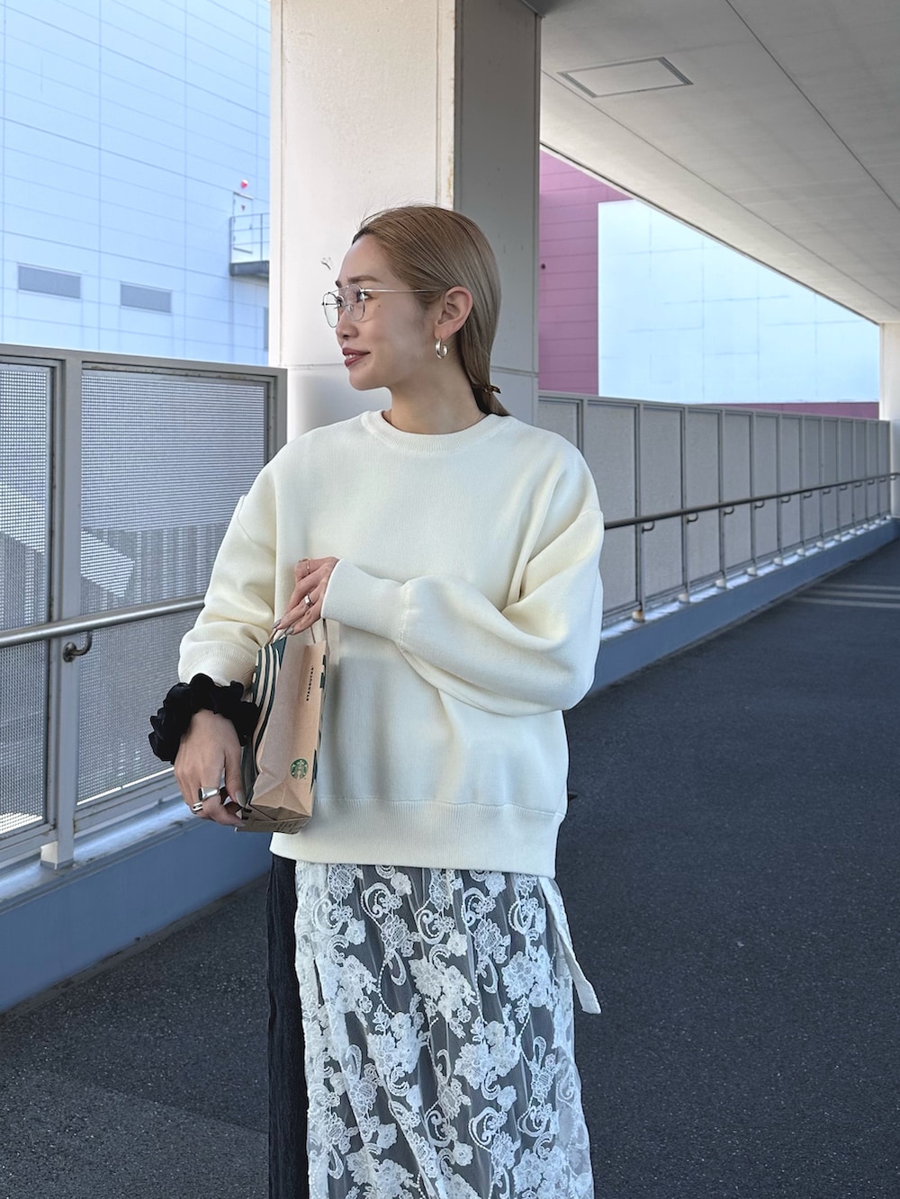 ホワイト系のニット/セーター、ホワイト系のスカート、ブルー系のデニムパンツを着用したレディースの冬コーディネートの3枚目の写真