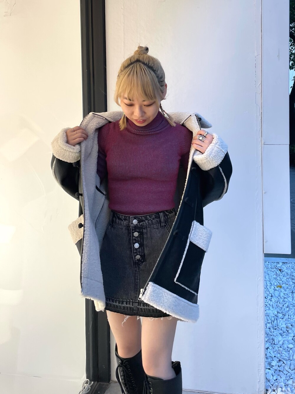 ブラック系のムートンコート、ブラック系のデニムパンツ、レッド系のニット/セーターを着用したレディースの夏コーディネートの7枚目の写真