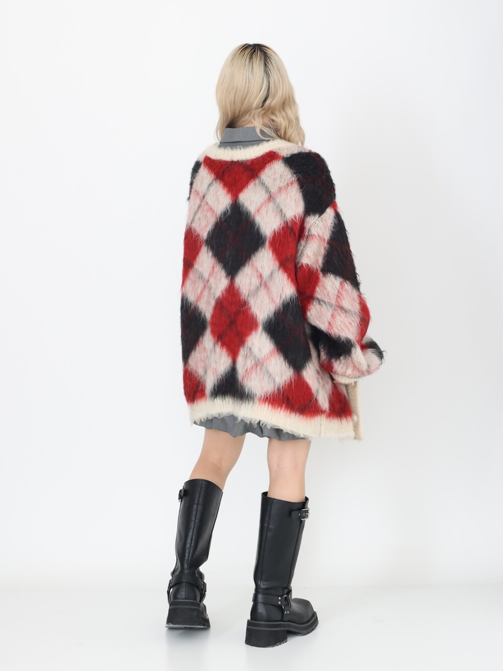 グレー系のワンピース、ブラック系のブーツ、ホワイト系のカーディガン/ボレロを着用したレディースの秋コーディネートの2枚目の写真