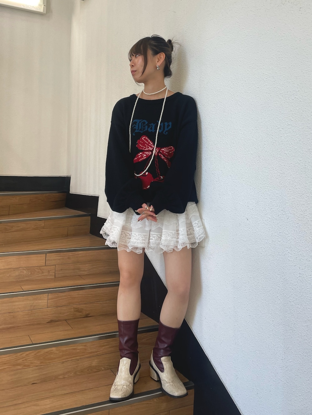 ブラック系のニット/セーター、ホワイト系のネックレスを着用したレディースの秋コーディネートの2枚目の写真