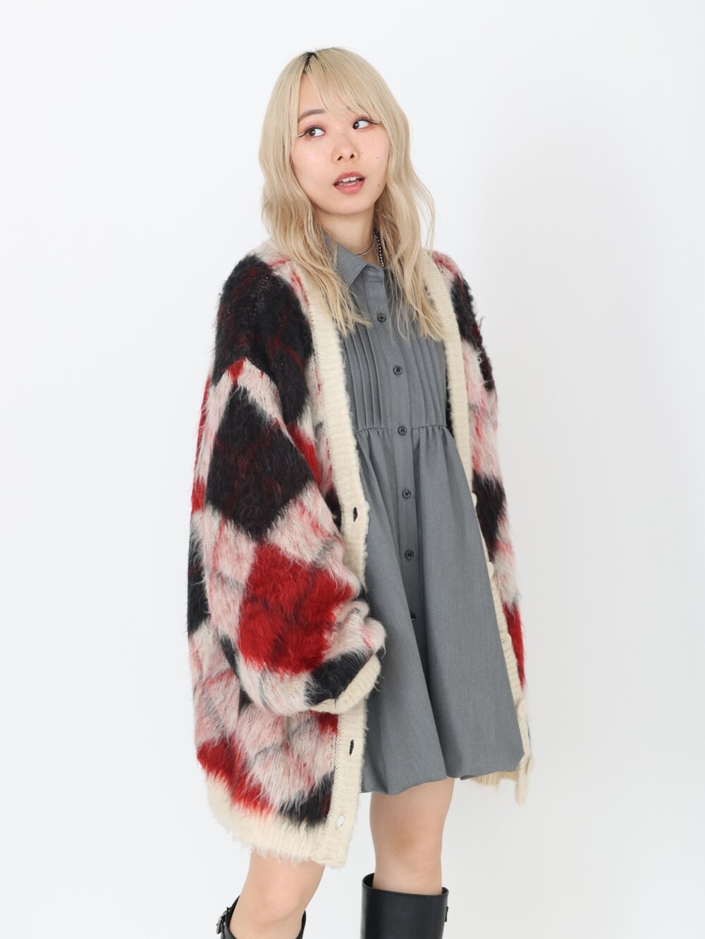 グレー系のワンピース、ブラック系のブーツ、ホワイト系のカーディガン/ボレロを着用したレディースの秋コーディネートの4枚目の写真