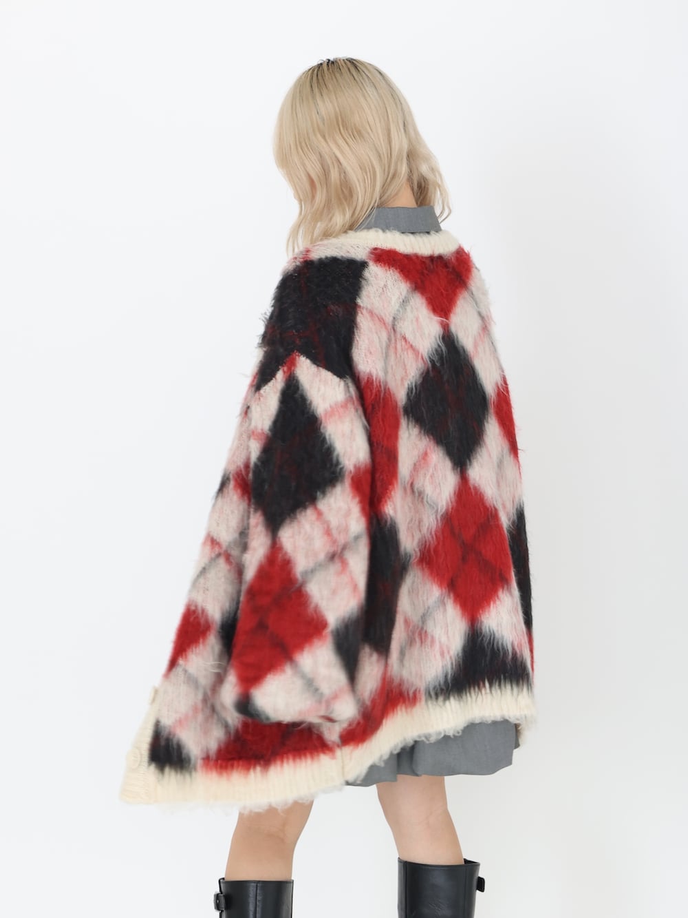 グレー系のワンピース、ブラック系のブーツ、ホワイト系のカーディガン/ボレロを着用したレディースの秋コーディネートの5枚目の写真