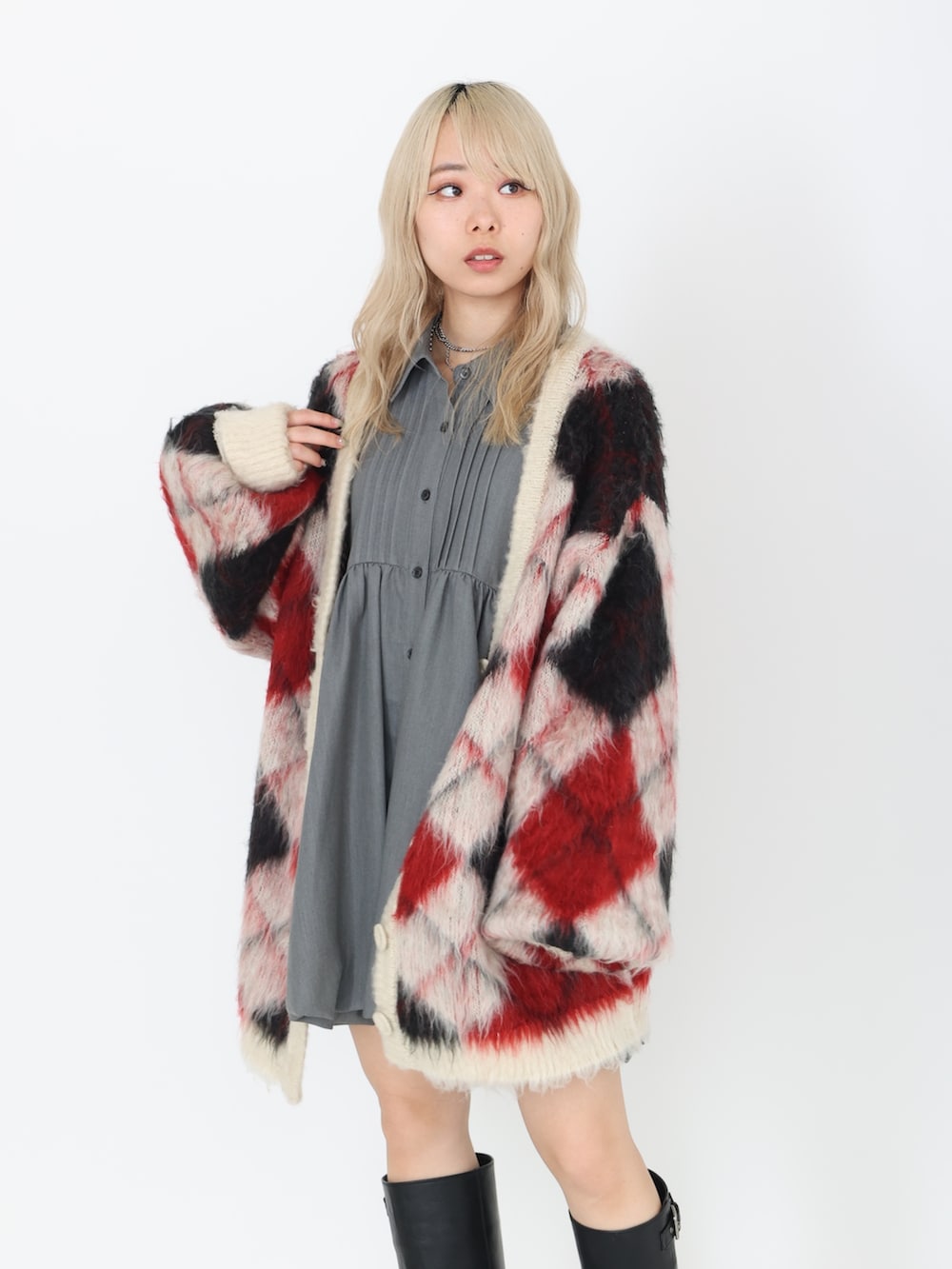 グレー系のワンピース、ブラック系のブーツ、ホワイト系のカーディガン/ボレロを着用したレディースの秋コーディネートの3枚目の写真