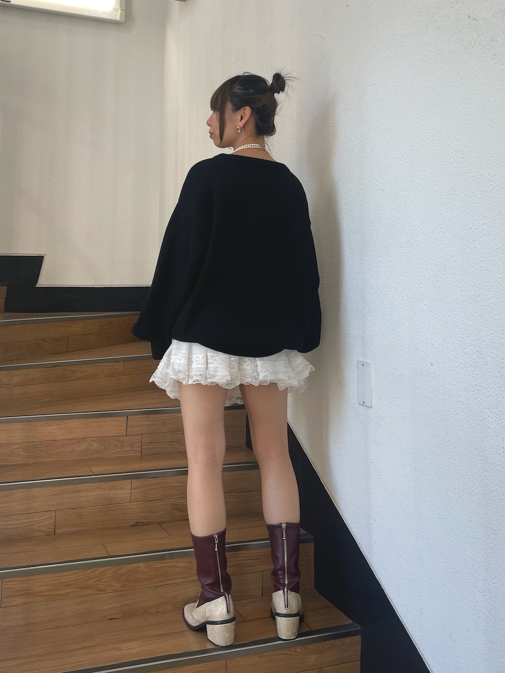 ブラック系のニット/セーター、ホワイト系のネックレスを着用したレディースの秋コーディネートの3枚目の写真