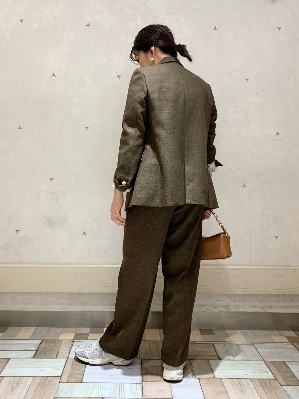 ブラウン系のテーラードジャケット、ブラウン系のその他パンツ、イエロー系のニット/セーターを着用したレディースの秋コーディネートの5枚目の写真