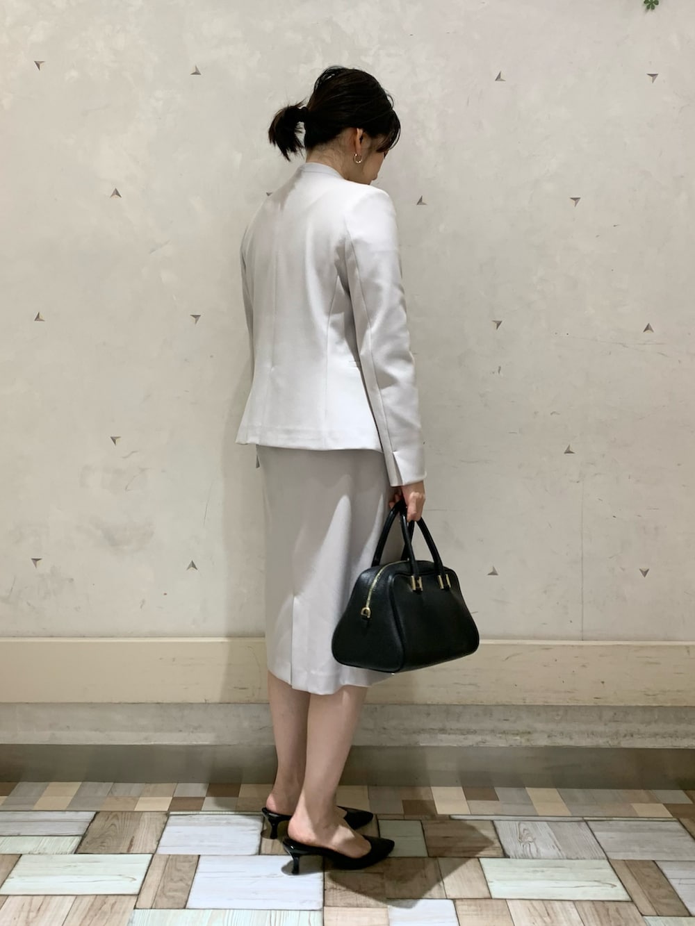 ベージュ系のノーカラージャケット、ベージュ系のスカート、ベージュ系のニット/セーターを着用したレディースの冬コーディネートの3枚目の写真