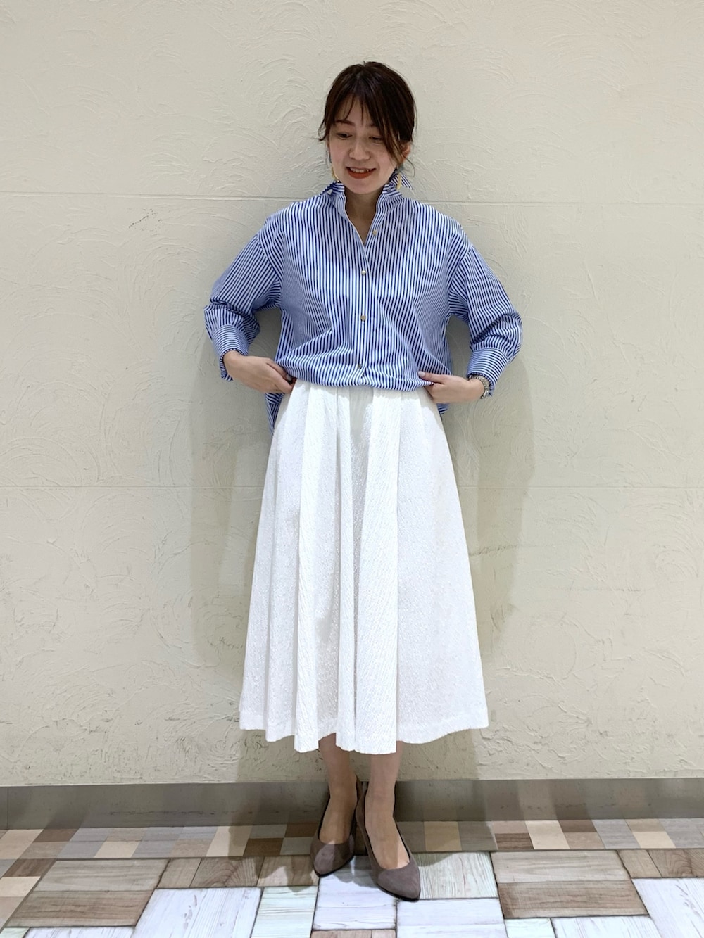 ブルー系のシャツ/ブラウス、ホワイト系のスカートを着用したレディースの春コーディネートの3枚目の写真