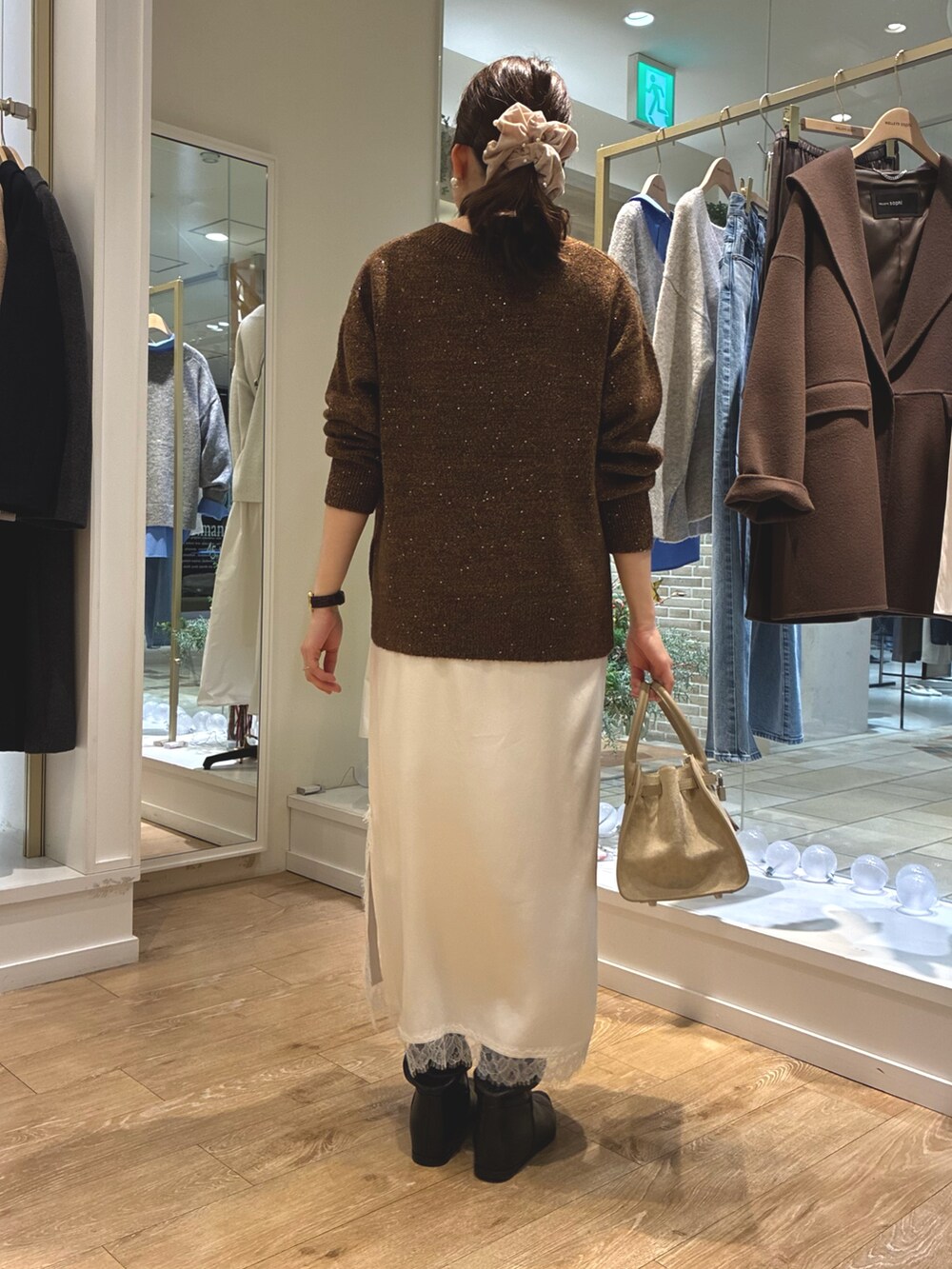 ブラウン系のニット/セーター、ホワイト系のワンピース、ベージュ系のトートバッグを着用したレディースの冬コーディネートの4枚目の写真