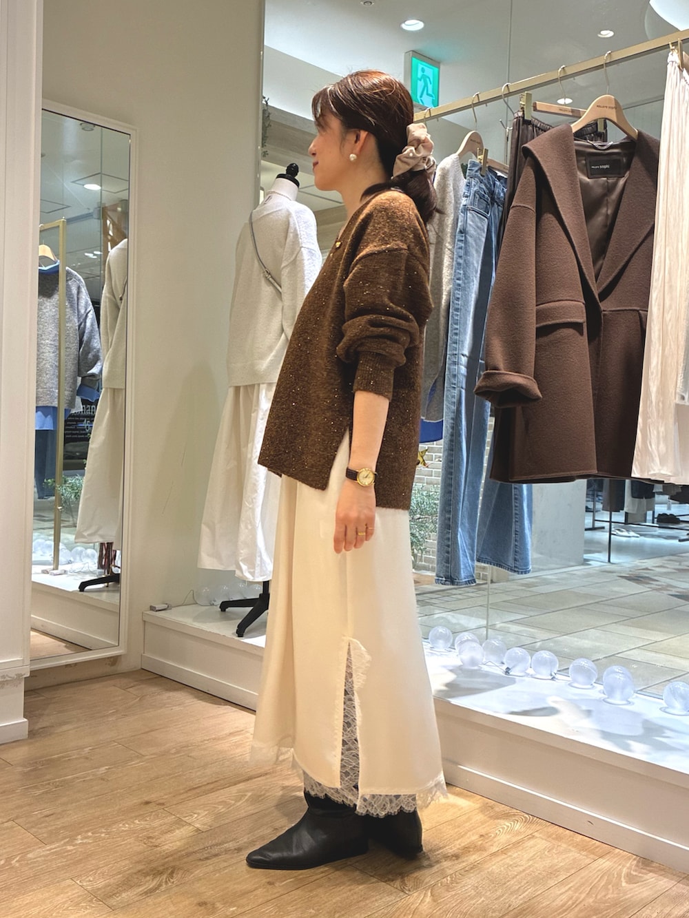 ブラウン系のニット/セーター、ホワイト系のワンピース、ベージュ系のトートバッグを着用したレディースの冬コーディネートの2枚目の写真