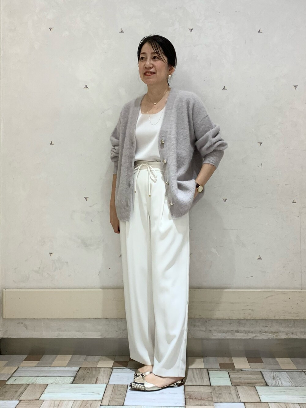 グレー系のカーディガン/ボレロ、ホワイト系のタンクトップ、ホワイト系のその他パンツを着用したレディースの秋コーディネートの5枚目の写真