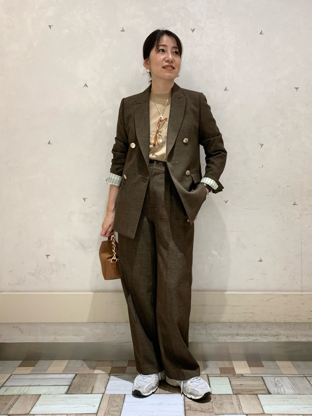 ブラウン系のテーラードジャケット、ブラウン系のその他パンツ、イエロー系のニット/セーターを着用したレディースの秋コーディネートの4枚目の写真