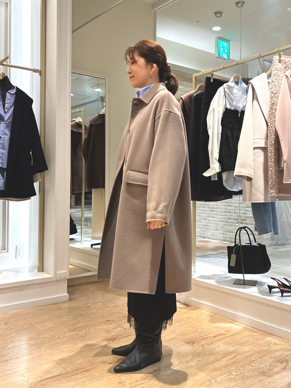 グリーン系のステンカラーコート、ブラック系のスカート、ブルー系のシャツ/ブラウスを着用したレディースの秋コーディネートの2枚目の写真