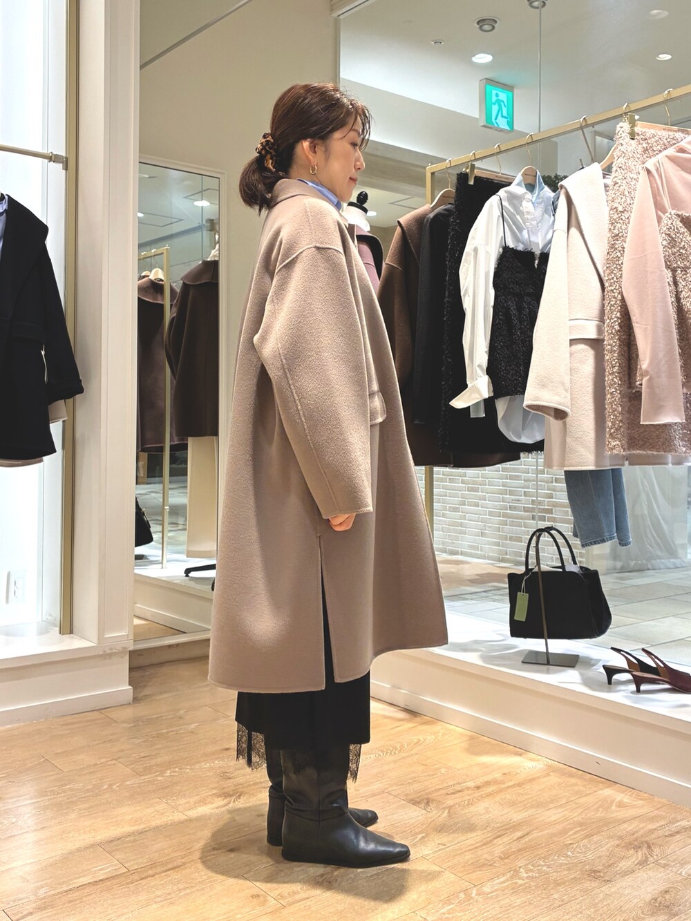 グリーン系のステンカラーコート、ブラック系のスカート、ブルー系のシャツ/ブラウスを着用したレディースの秋コーディネートの8枚目の写真