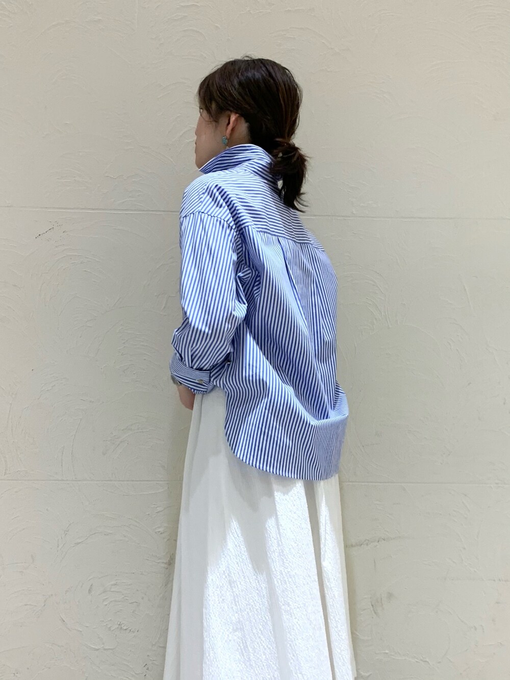 ブルー系のシャツ/ブラウス、ホワイト系のスカートを着用したレディースの春コーディネートの4枚目の写真