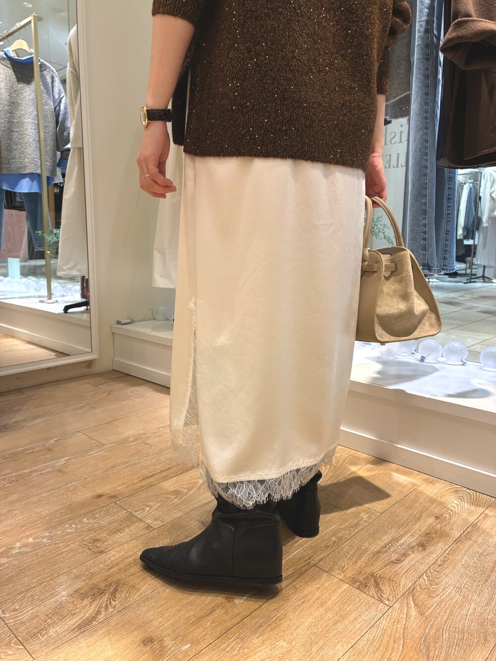 ブラウン系のニット/セーター、ホワイト系のワンピース、ベージュ系のトートバッグを着用したレディースの冬コーディネートの7枚目の写真