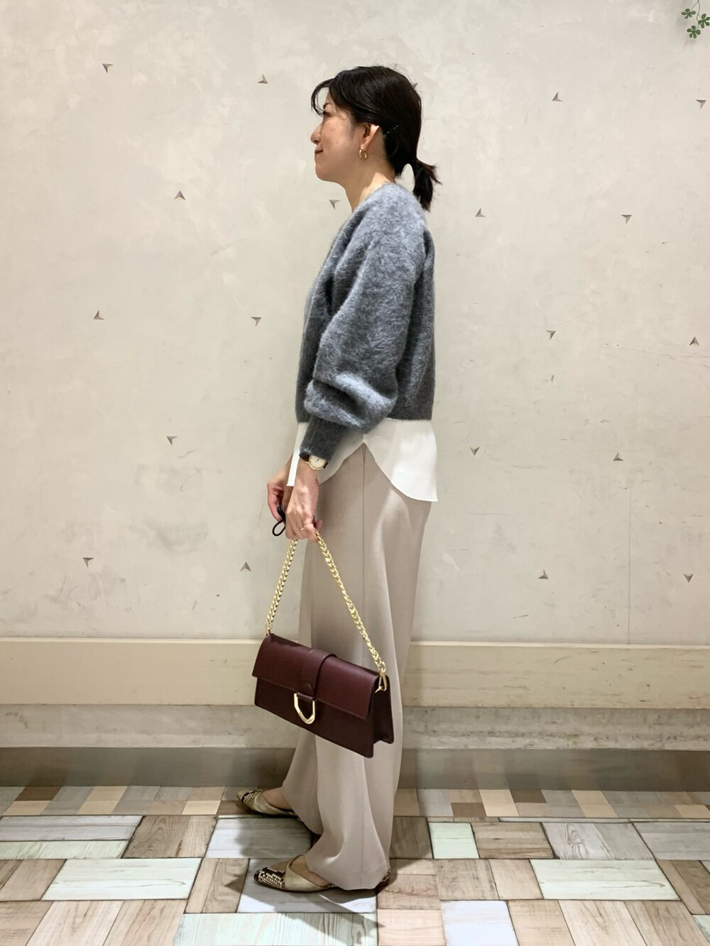 グレー系のニット/セーター、ホワイト系のタンクトップ、ベージュ系のその他パンツを着用したレディースの秋コーディネートの4枚目の写真