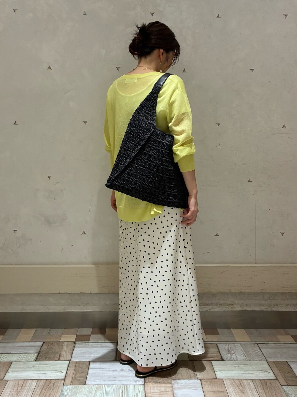 ホワイト系のスカート、イエロー系のニット/セーター、ブラック系のショルダーバッグを着用したレディースの春コーディネートの4枚目の写真