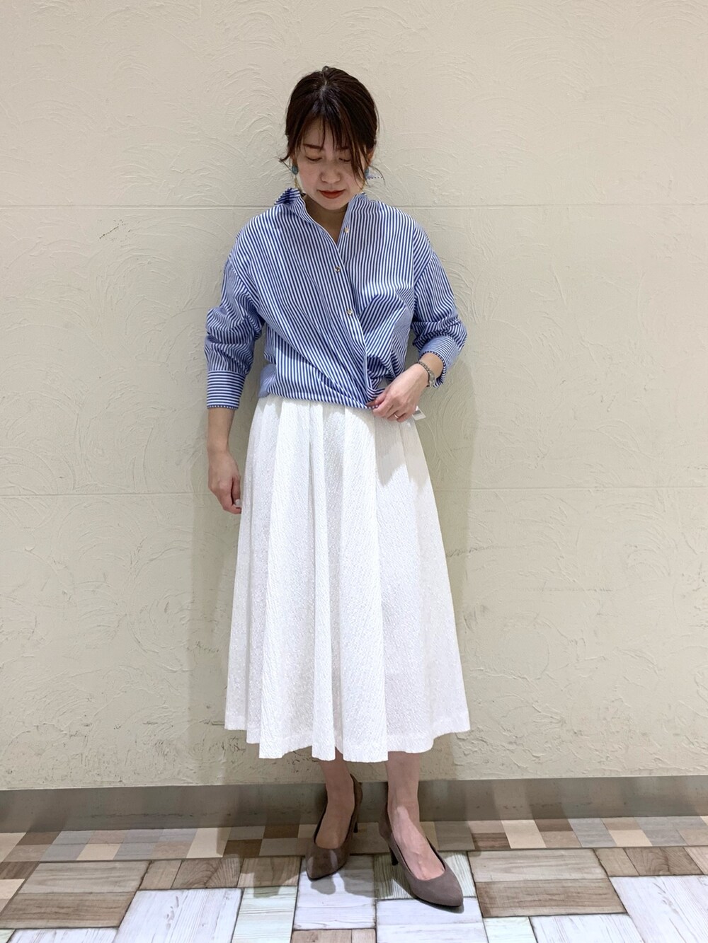 ブルー系のシャツ/ブラウス、ホワイト系のスカートを着用したレディースの春コーディネートの5枚目の写真