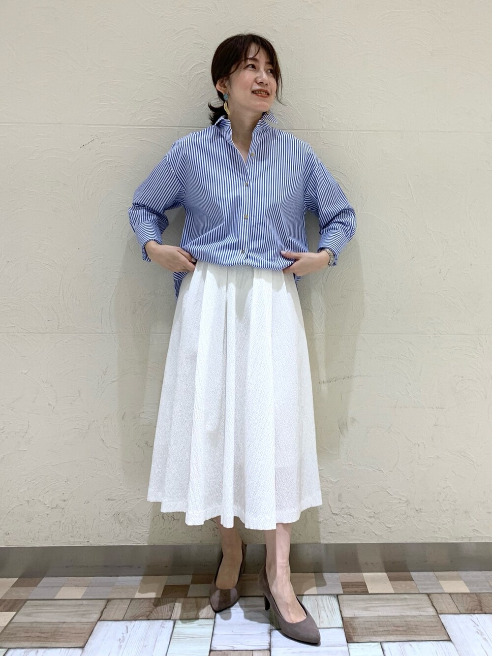 ブルー系のシャツ/ブラウス、ホワイト系のスカートを着用したレディースの春コーディネートの2枚目の写真