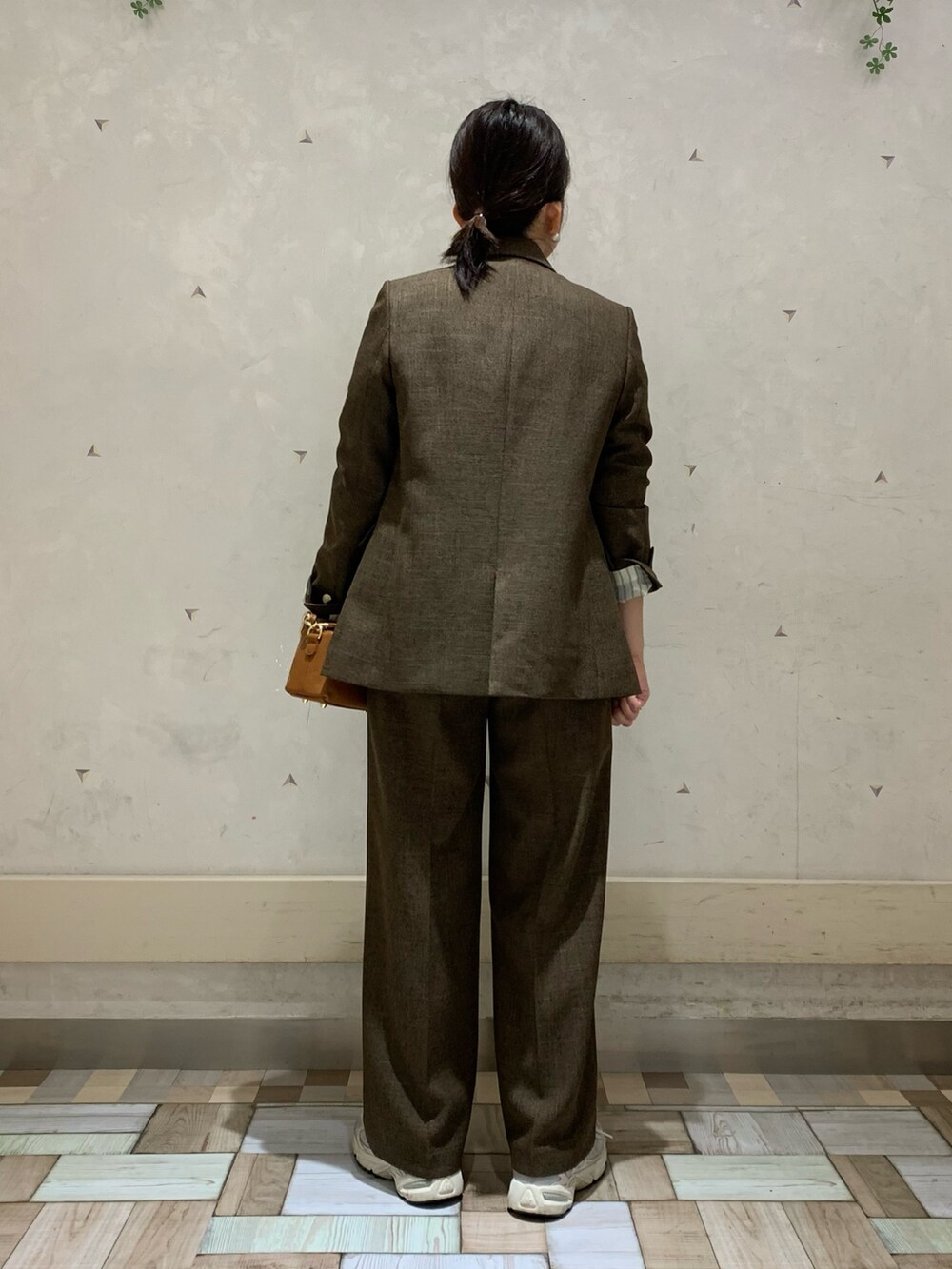 ブラウン系のテーラードジャケット、ブラウン系のその他パンツ、イエロー系のニット/セーターを着用したレディースの秋コーディネートの3枚目の写真