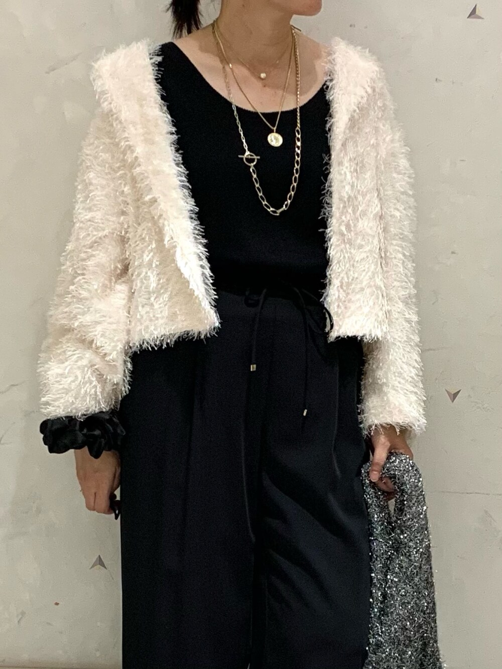 ホワイト系のノーカラージャケット、ブラック系のその他パンツ、ブラック系のタンクトップを着用したレディースの秋コーディネートの4枚目の写真