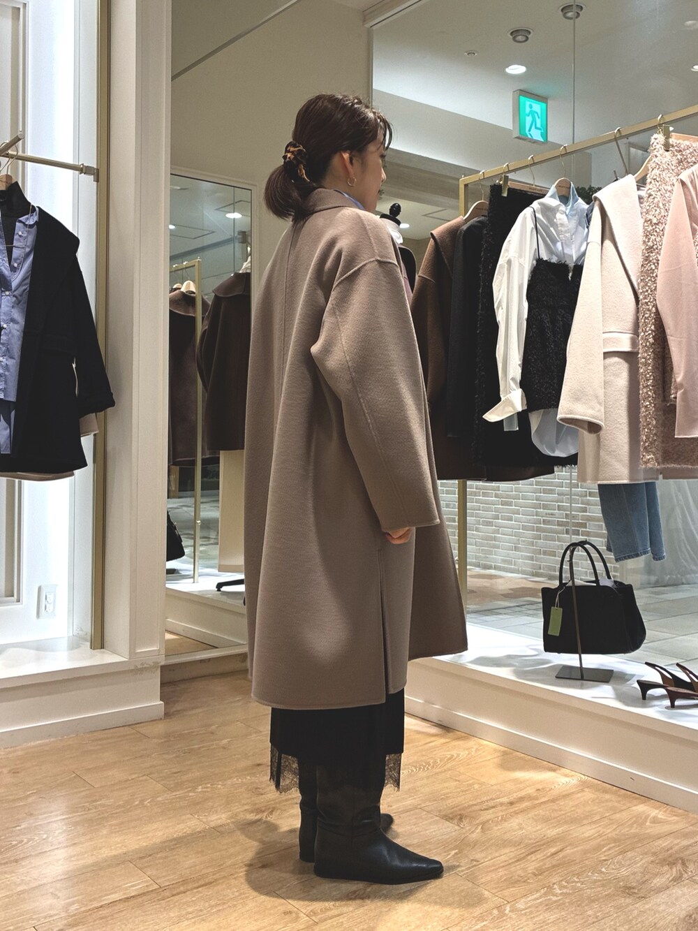 グリーン系のステンカラーコート、ブラック系のスカート、ブルー系のシャツ/ブラウスを着用したレディースの秋コーディネートの7枚目の写真