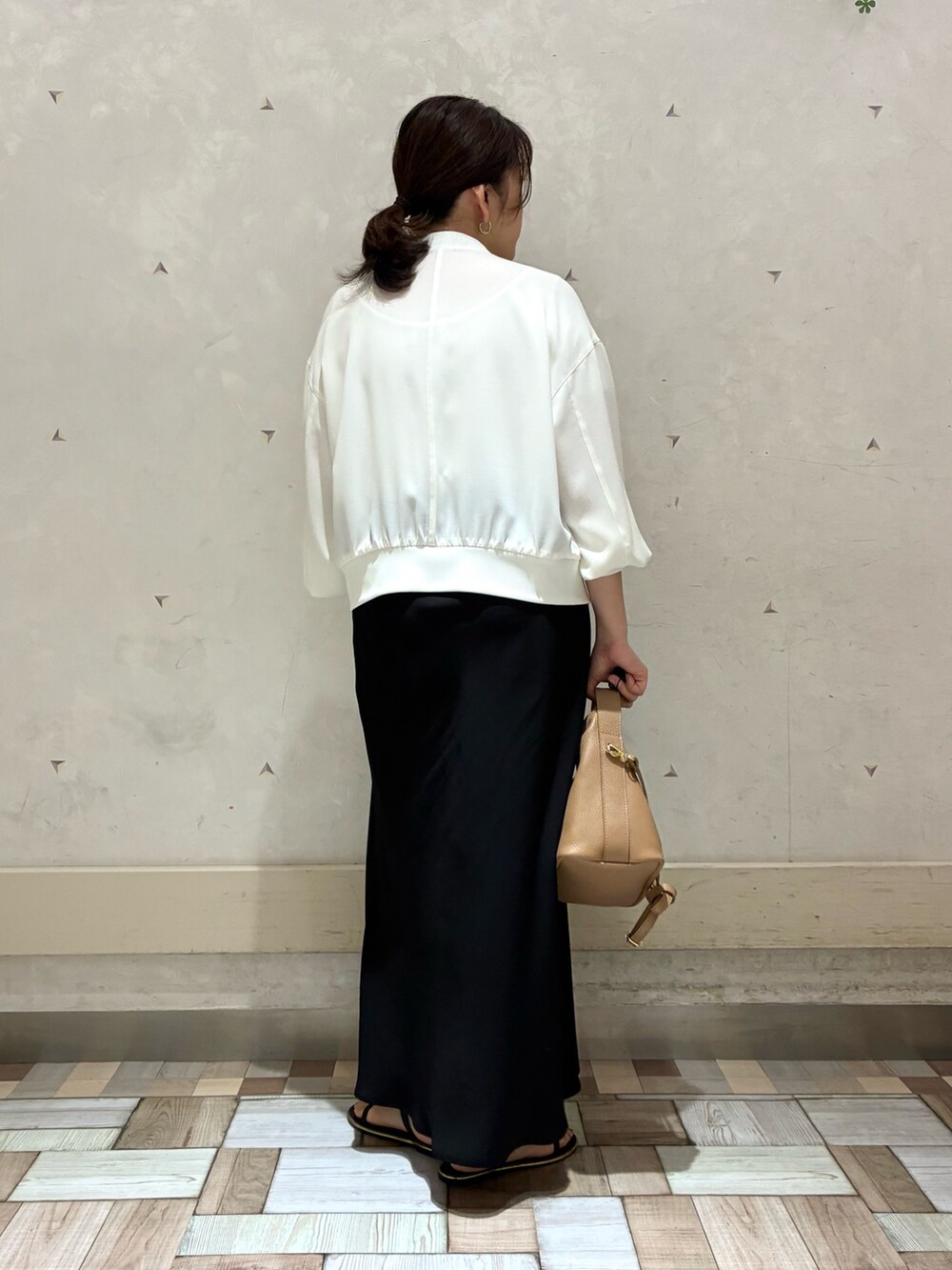 ホワイト系のブルゾン、ブラック系のスカートを着用したレディースの春コーディネートの4枚目の写真