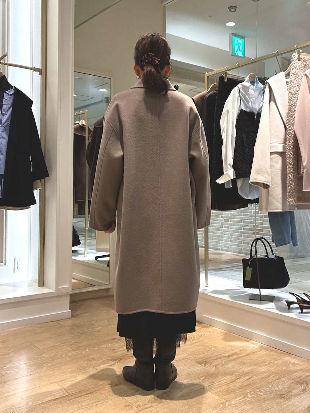 グリーン系のステンカラーコート、ブラック系のスカート、ブルー系のシャツ/ブラウスを着用したレディースの秋コーディネートの5枚目の写真