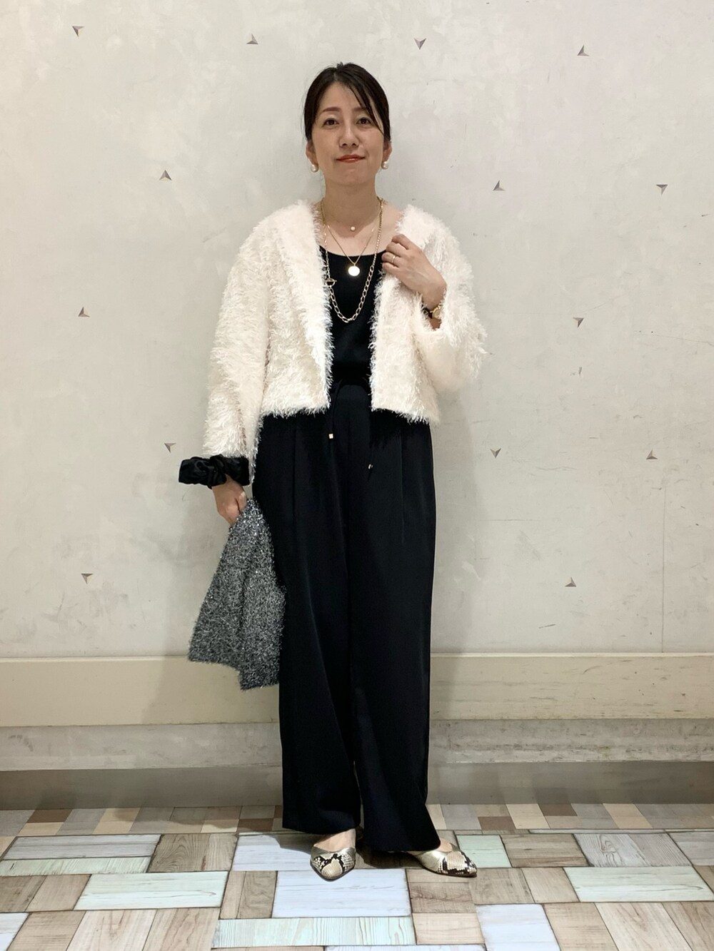 ホワイト系のノーカラージャケット、ブラック系のその他パンツ、ブラック系のタンクトップを着用したレディースの秋コーディネートの2枚目の写真