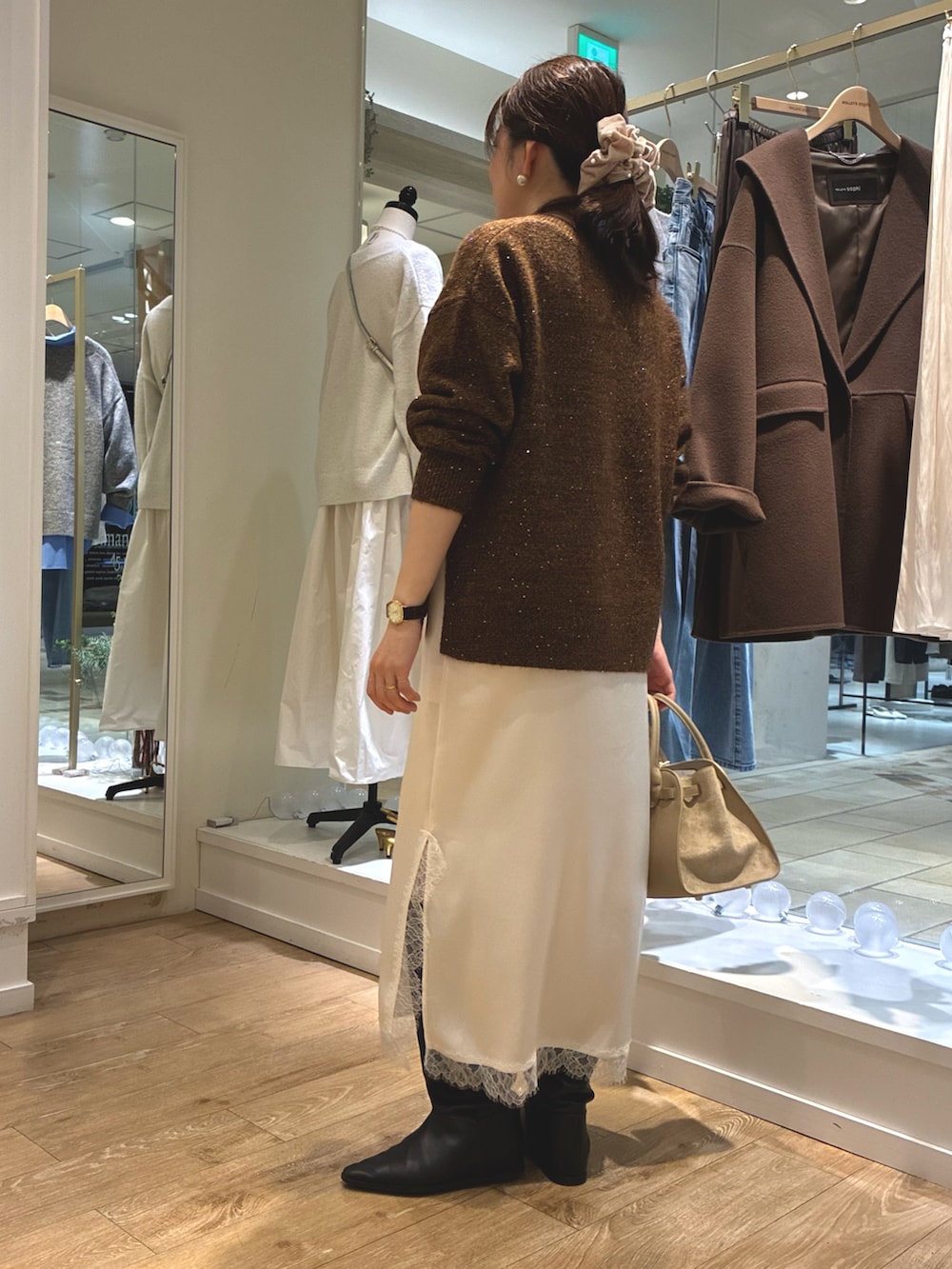 ブラウン系のニット/セーター、ホワイト系のワンピース、ベージュ系のトートバッグを着用したレディースの冬コーディネートの3枚目の写真