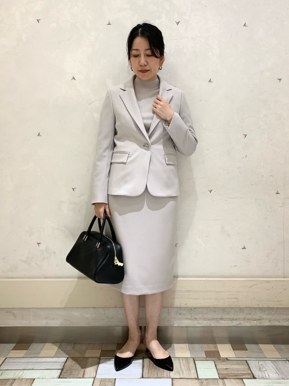 ベージュ系のノーカラージャケット、ベージュ系のスカート、ベージュ系のニット/セーターを着用したレディースの冬コーディネートの5枚目の写真