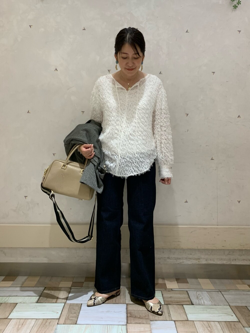 グレー系のテーラードジャケット、ホワイト系のシャツ/ブラウス、ベージュ系のショルダーバッグを着用したレディースの秋コーディネートの4枚目の写真