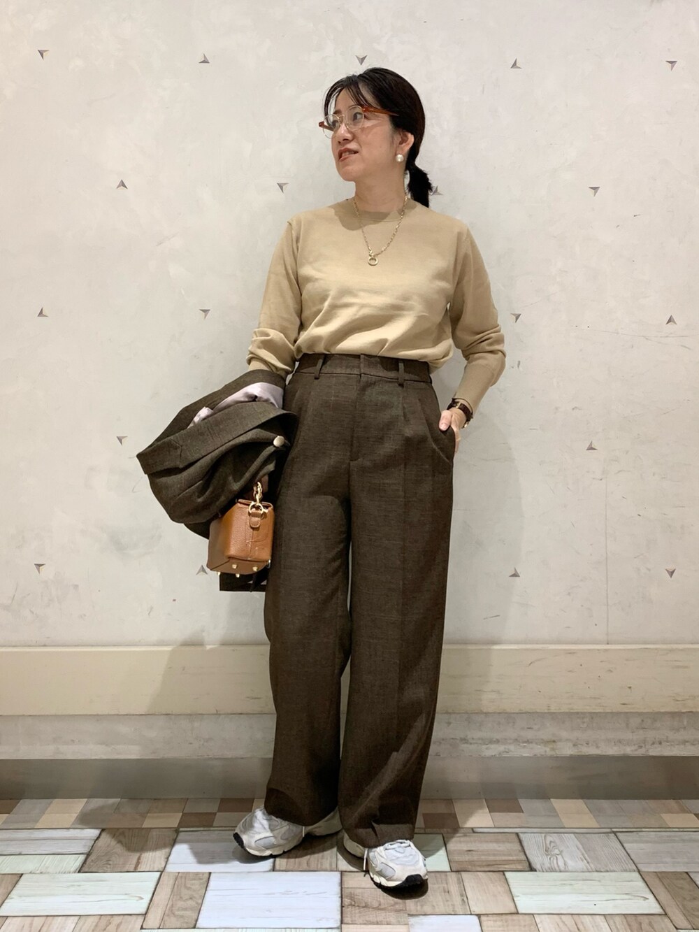 ブラウン系のテーラードジャケット、ブラウン系のその他パンツ、イエロー系のニット/セーターを着用したレディースの秋コーディネートの6枚目の写真