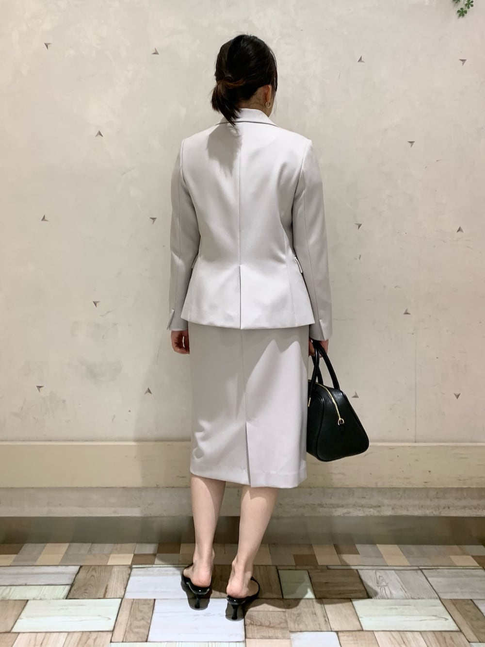 ベージュ系のノーカラージャケット、ベージュ系のスカート、ベージュ系のニット/セーターを着用したレディースの冬コーディネートの4枚目の写真