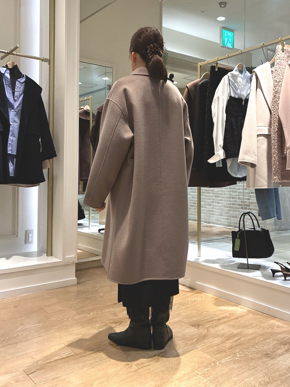 グリーン系のステンカラーコート、ブラック系のスカート、ブルー系のシャツ/ブラウスを着用したレディースの秋コーディネートの4枚目の写真