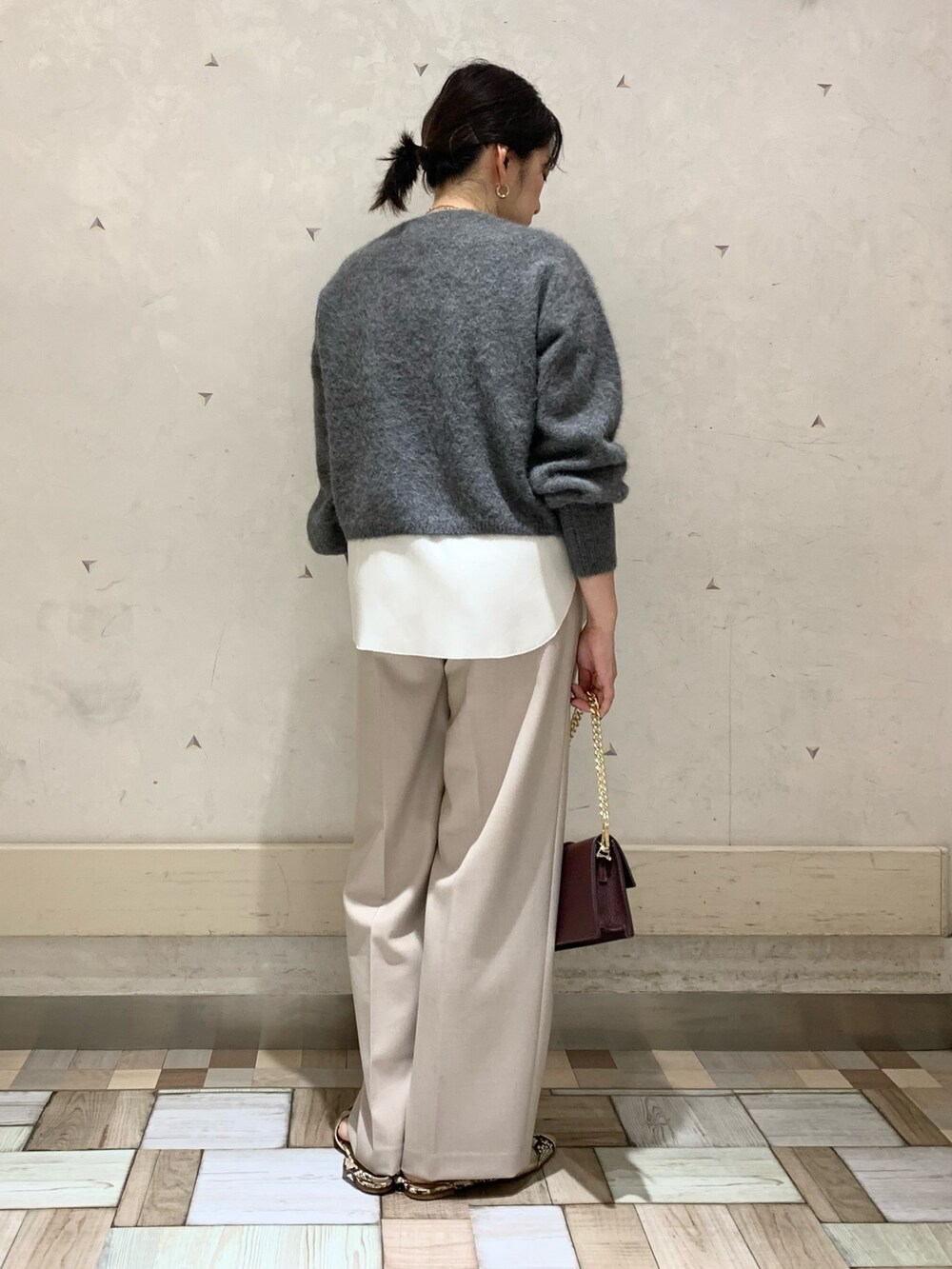 グレー系のニット/セーター、ホワイト系のタンクトップ、ベージュ系のその他パンツを着用したレディースの秋コーディネートの3枚目の写真