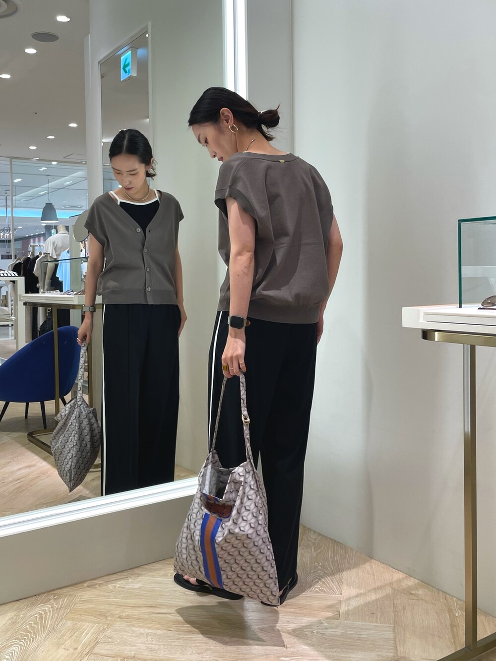 ブラック系のその他パンツ、グリーン系のベスト、ブラック系のキャミソールを着用したレディースの夏コーディネートの5枚目の写真