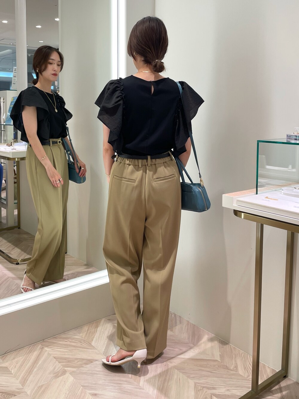 ブラック系のTシャツ/カットソー、ベージュ系のその他パンツ、ブルー系のボストンバッグを着用したレディースの夏コーディネートの4枚目の写真