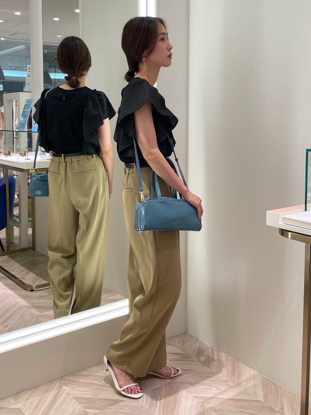 ブラック系のTシャツ/カットソー、ベージュ系のその他パンツ、ブルー系のボストンバッグを着用したレディースの夏コーディネートの3枚目の写真