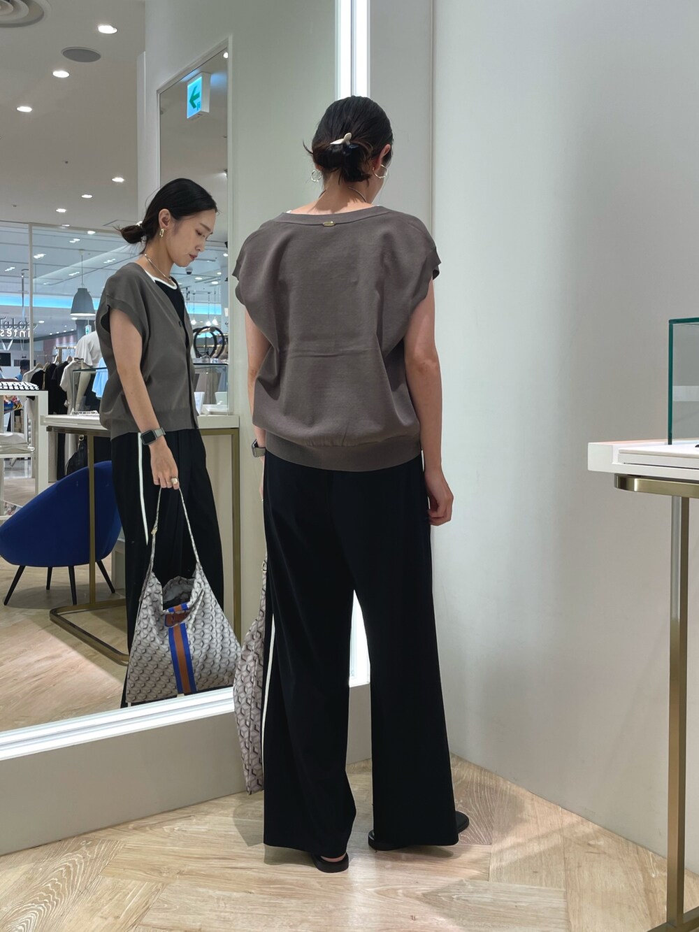 ブラック系のその他パンツ、グリーン系のベスト、ブラック系のキャミソールを着用したレディースの夏コーディネートの4枚目の写真