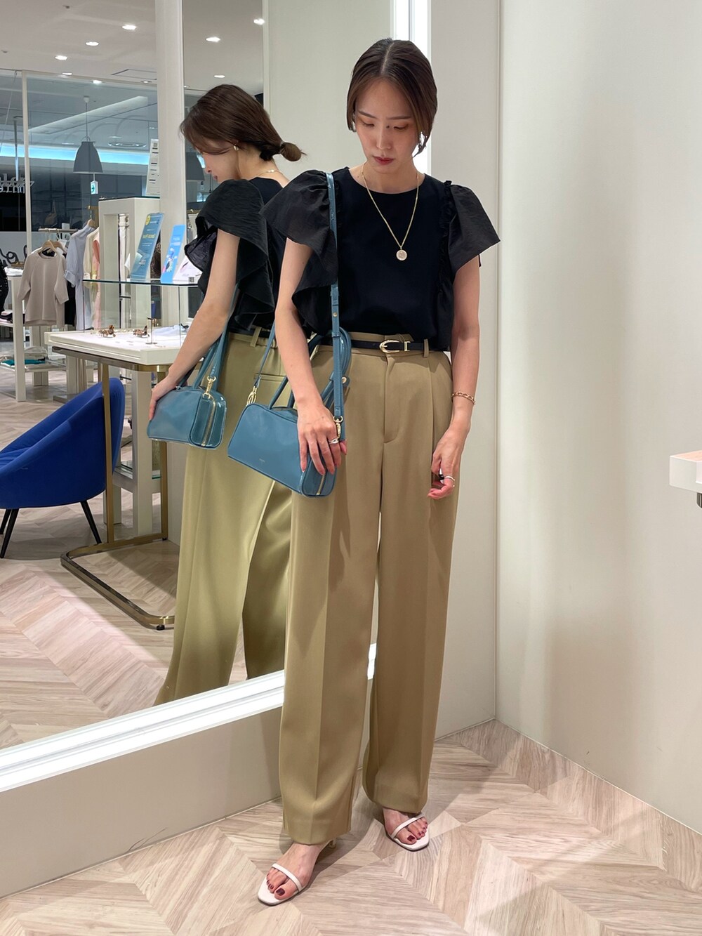 ブラック系のTシャツ/カットソー、ベージュ系のその他パンツ、ブルー系のボストンバッグを着用したレディースの夏コーディネートの2枚目の写真