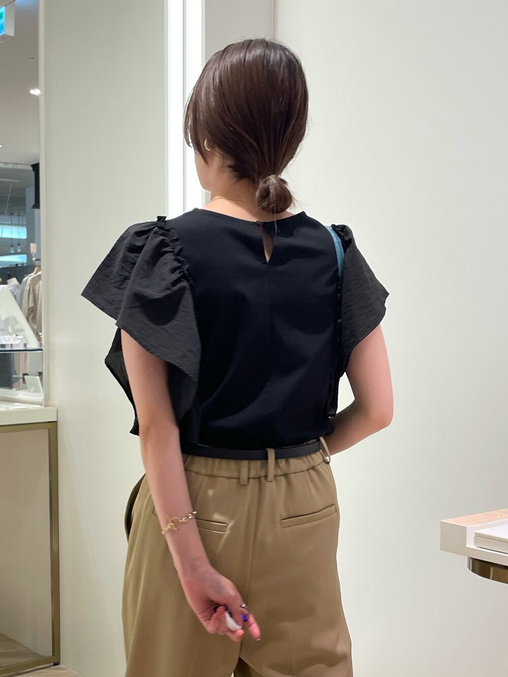 ブラック系のTシャツ/カットソー、ベージュ系のその他パンツ、ブルー系のボストンバッグを着用したレディースの夏コーディネートの6枚目の写真