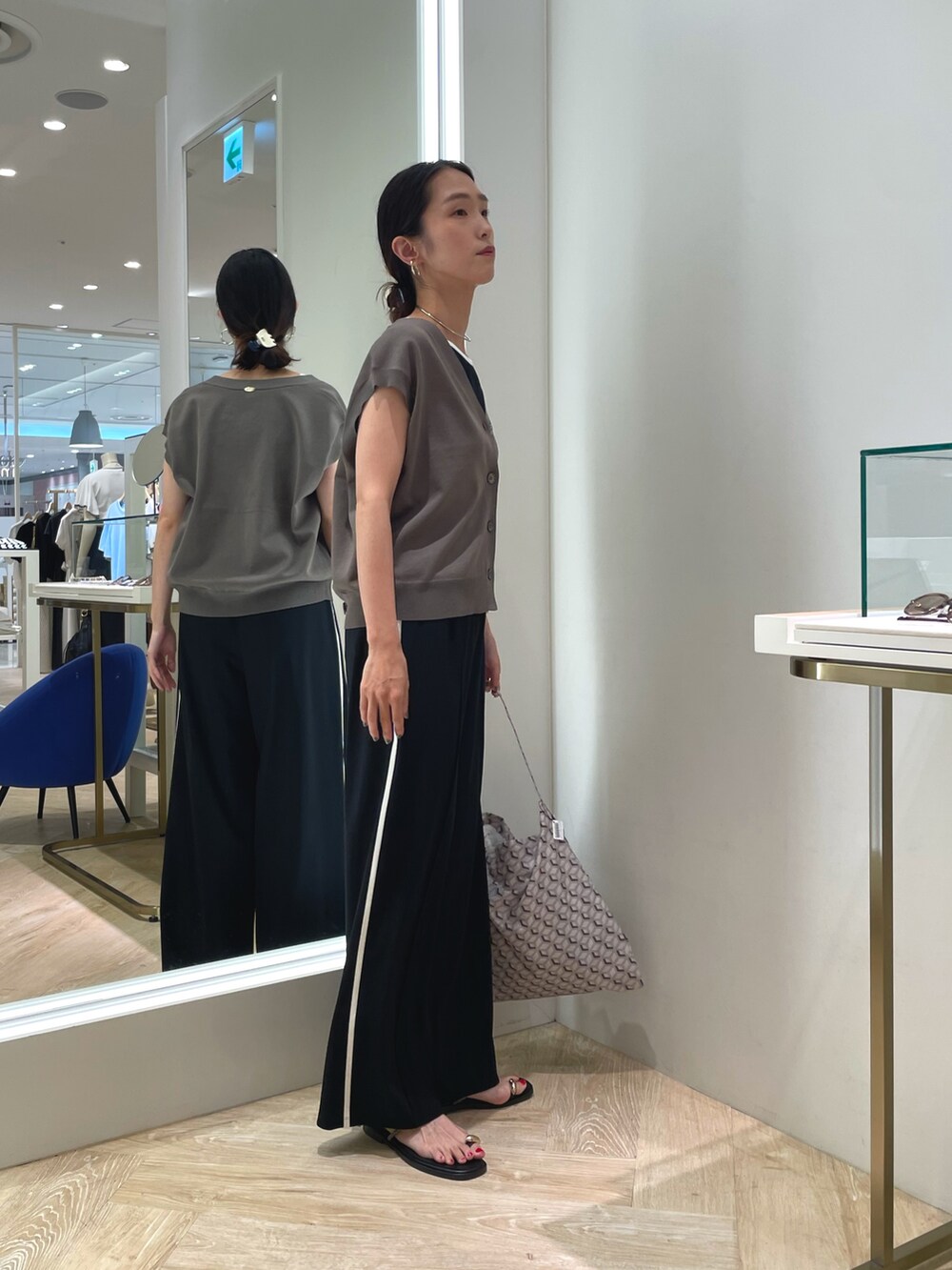 ブラック系のその他パンツ、グリーン系のベスト、ブラック系のキャミソールを着用したレディースの夏コーディネートの6枚目の写真
