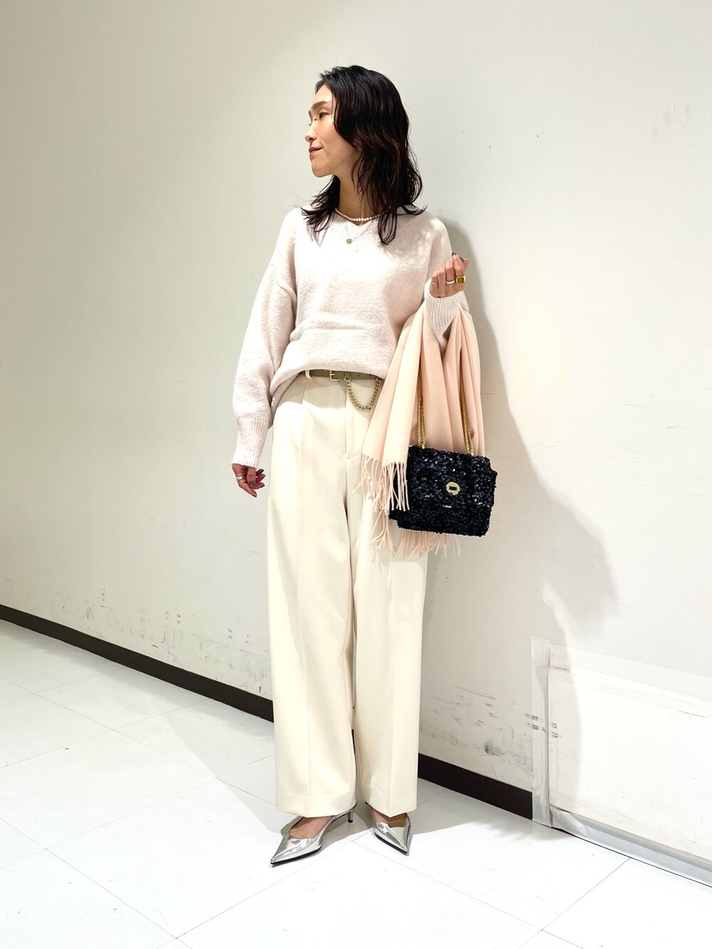 ピンク系のニット/セーター、ホワイト系のその他パンツ、ブラック系のショルダーバッグを着用したレディースの冬コーディネートの3枚目の写真