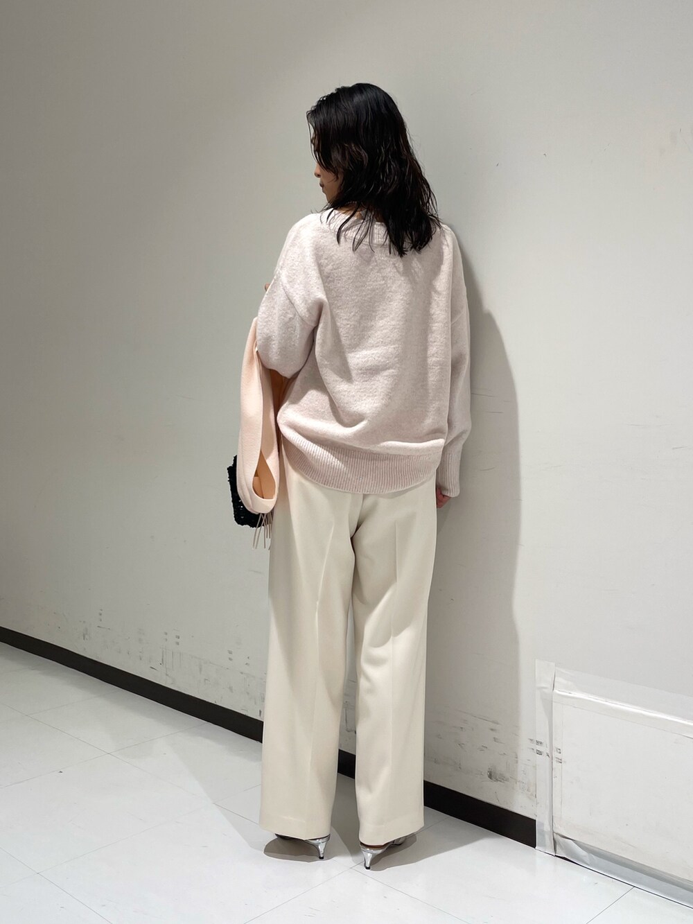 ピンク系のニット/セーター、ホワイト系のその他パンツ、ブラック系のショルダーバッグを着用したレディースの冬コーディネートの4枚目の写真