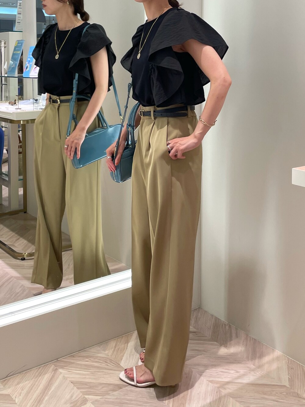 ブラック系のTシャツ/カットソー、ベージュ系のその他パンツ、ブルー系のボストンバッグを着用したレディースの夏コーディネートの5枚目の写真