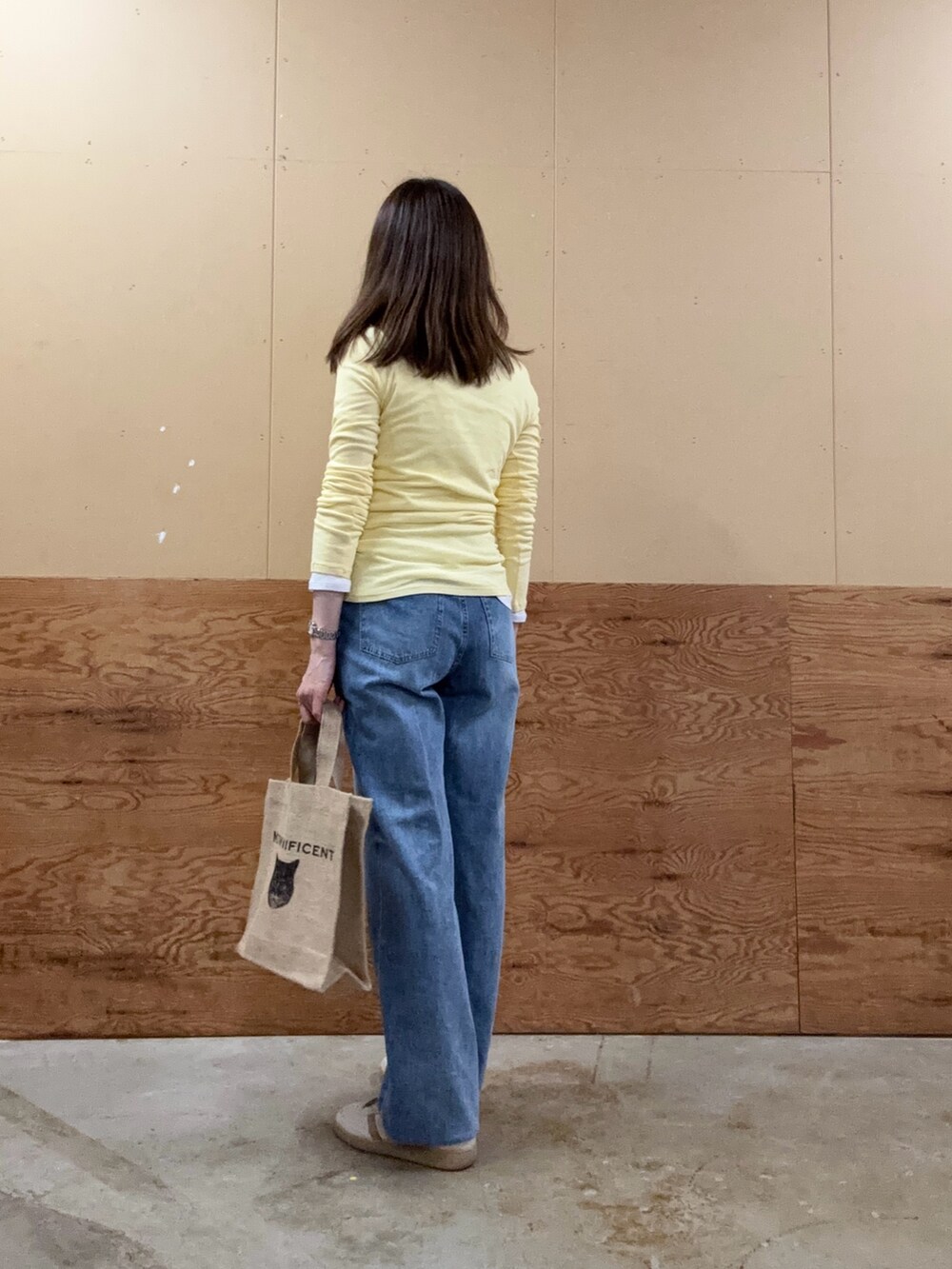 ブルー系のデニムパンツ、ブラック系のトートバッグ、ホワイト系のTシャツ/カットソーを着用したレディースの夏コーディネートの2枚目の写真