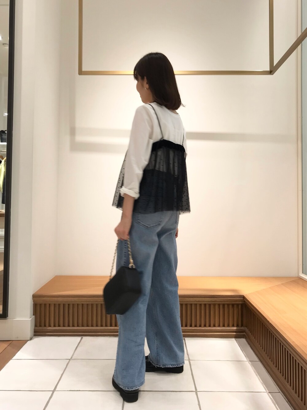 ブラック系のシャツ/ブラウス、ホワイト系のTシャツ/カットソー、ブラック系のショルダーバッグを着用したレディースの秋コーディネートの2枚目の写真